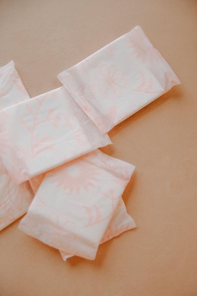 Close-up of sanitary pads on a beige surface, promoting menstrual hygiene.